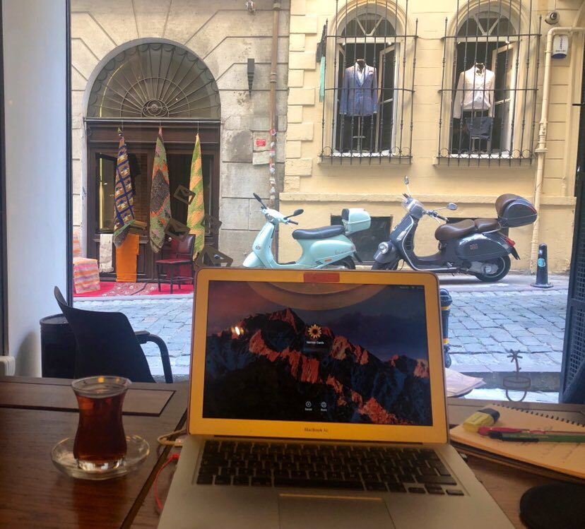 Uzaktan Çalışma Bilgisayar Mac Defter Kalem Pencere Manzara Çay Galata Workinton Motosiklet Digital Nomad